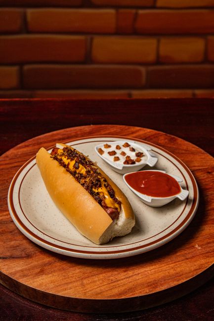 An all-beef hot dog on a poppy seed bun topped with yellow mustard, chopped onion, neon green relish, tomato wedges, a pickle spear, sport peppers, and a dash of celery salt.