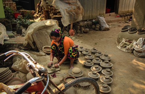 Free A woman crafts pottery traditionally in Cumilla's outdoor setting, showcasing local culture. Stock Photo