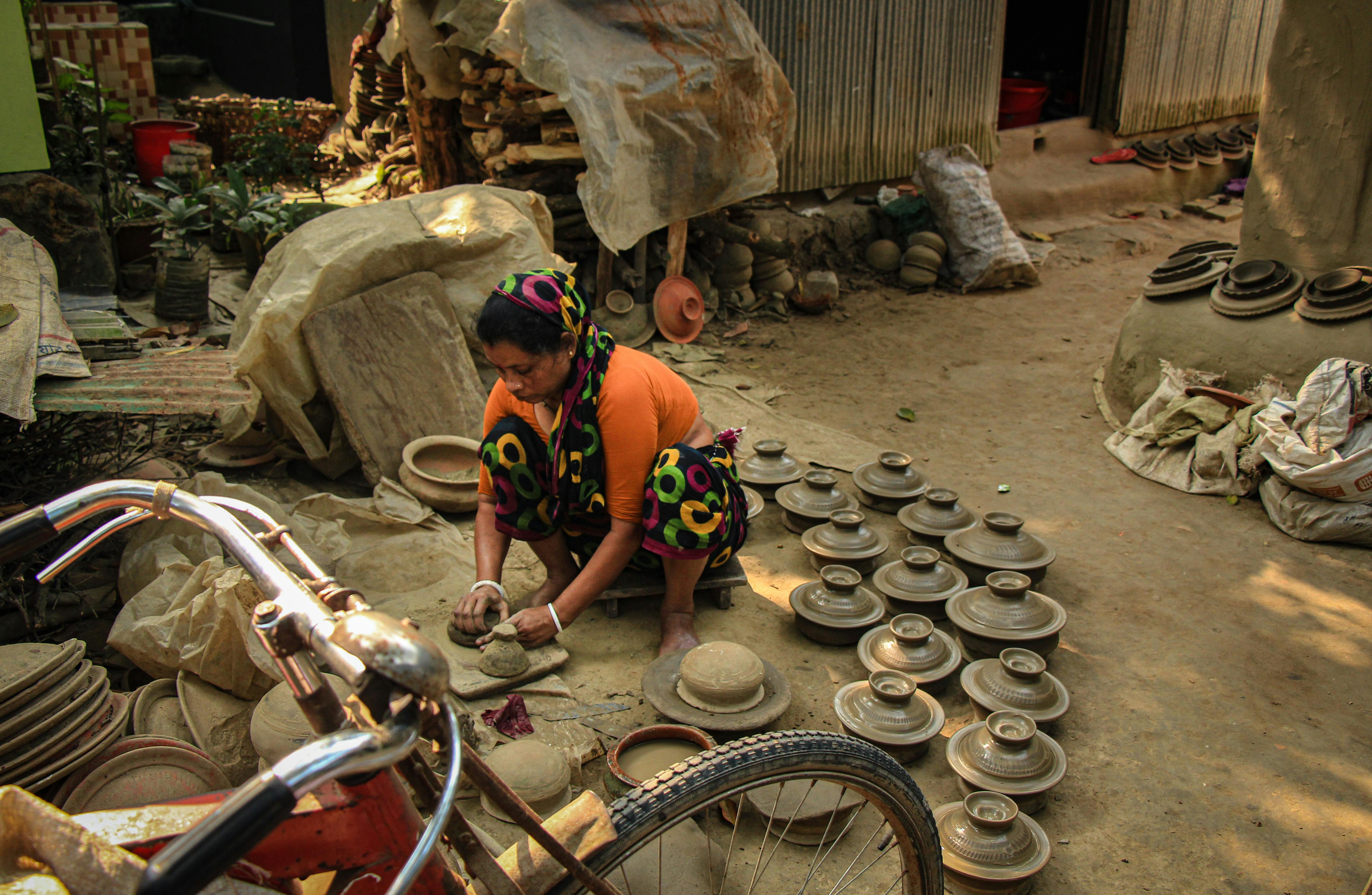 Kostenlos Eine Frau fertigt in Cumillas Naturlandschaft traditionelle Töpferwaren an und präsentiert so die lokale Kultur. Stock-Foto