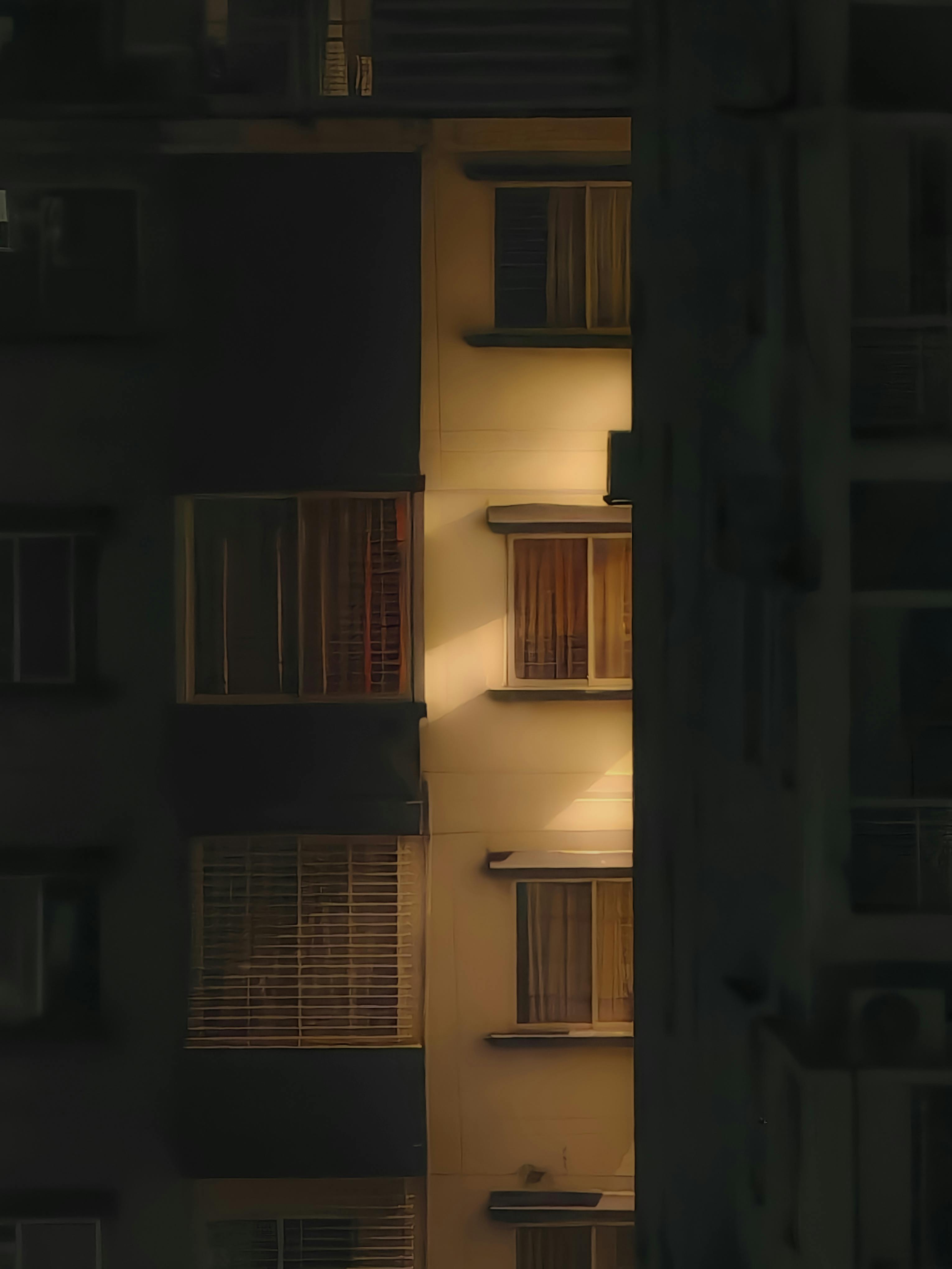 Ücretsiz Aydınlatılmış apartman pencerelerinin büyüleyici gece manzarası, şehir hayatına bir bakış sunuyor. Stok Fotoğraflar