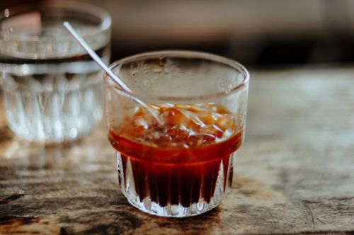 Free Refreshing glass of iced coffee on a wooden table, perfect for summer mornings. Stock Photo