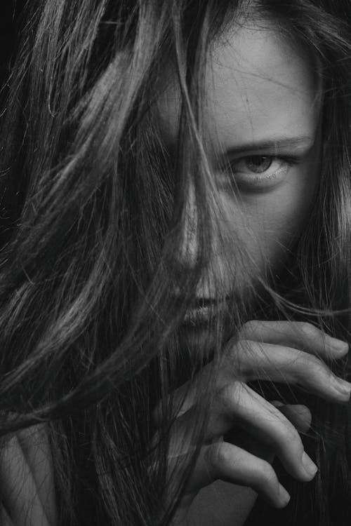 Grayscale Close-up Photo of Woman Posing with Her Hair Covering Part of Her Face