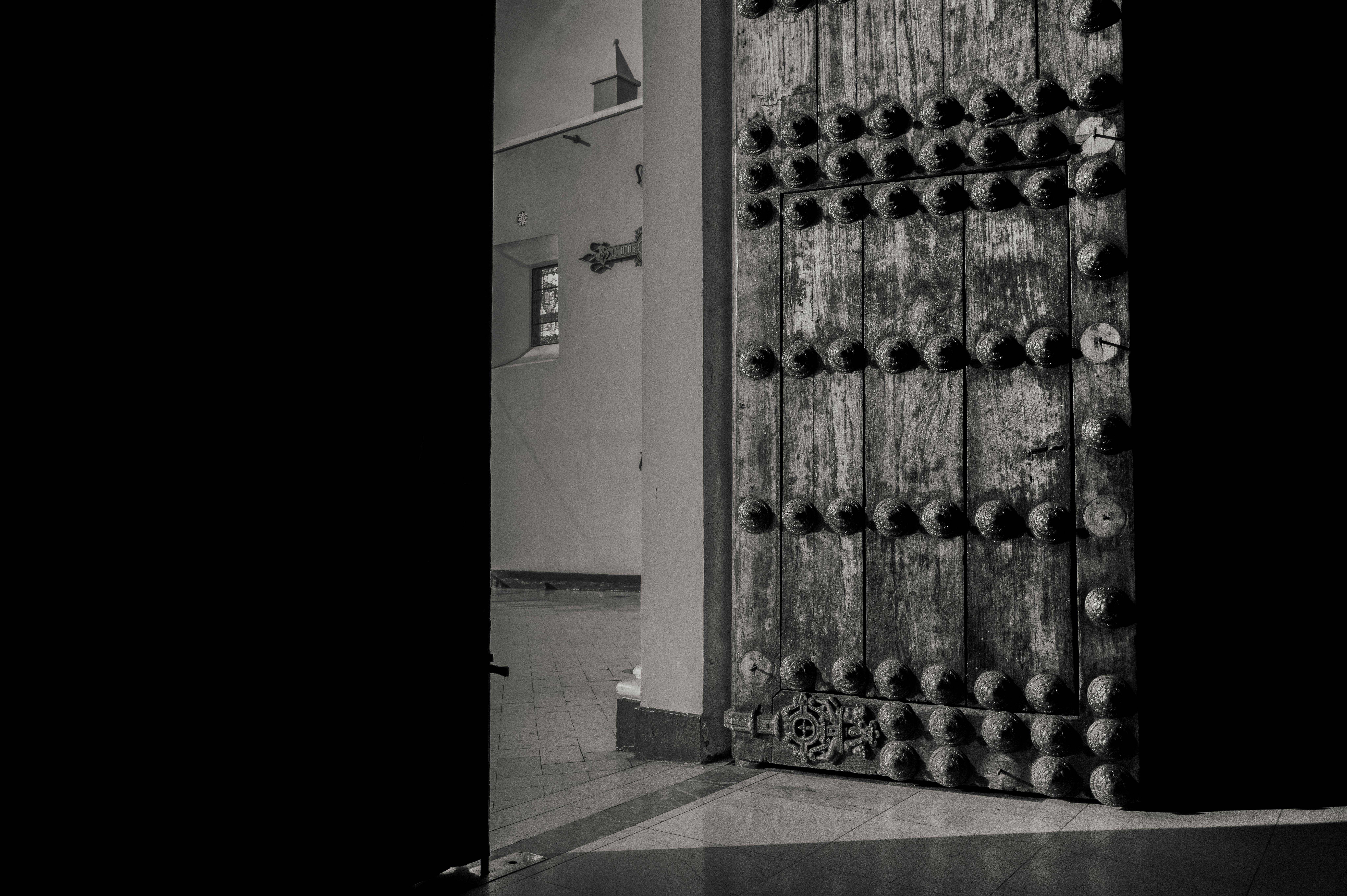 Gratuit Photo en noir et blanc d'une ancienne porte en bois à Trujillo, mettant en valeur des détails complexes et le patrimoine culturel. Photos