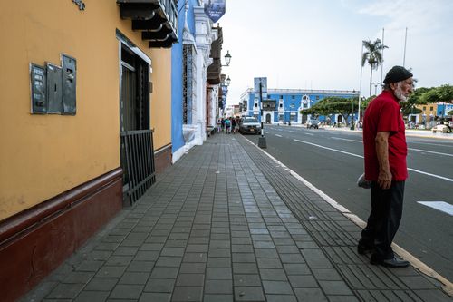 Free Vibrant street in Trujillo, Peru, showcasing colonial architecture and a local passerby. Stock Photo
