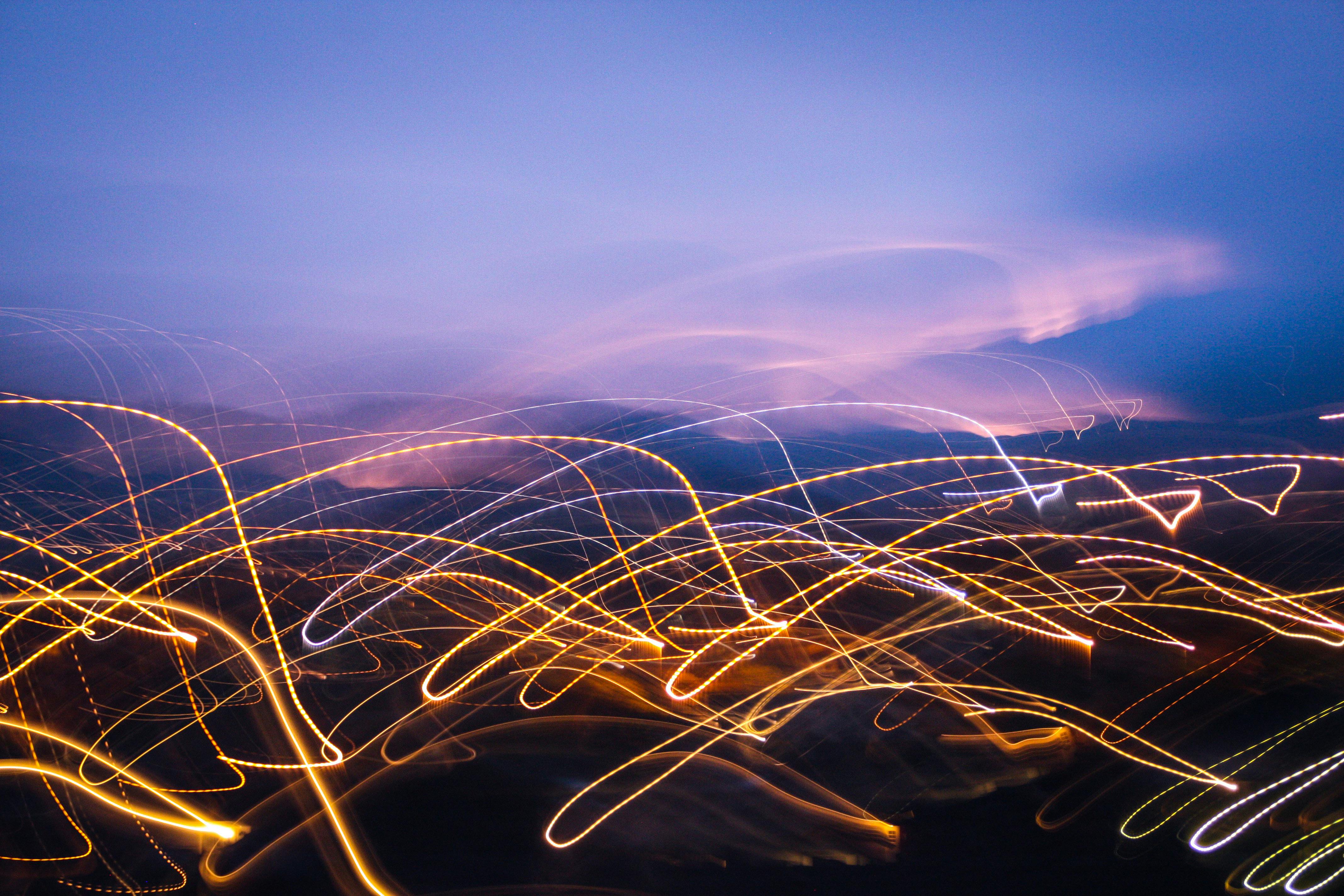 Dynamic abstract light trails in a vibrant night cityscape, evoking a sense of motion and energy.