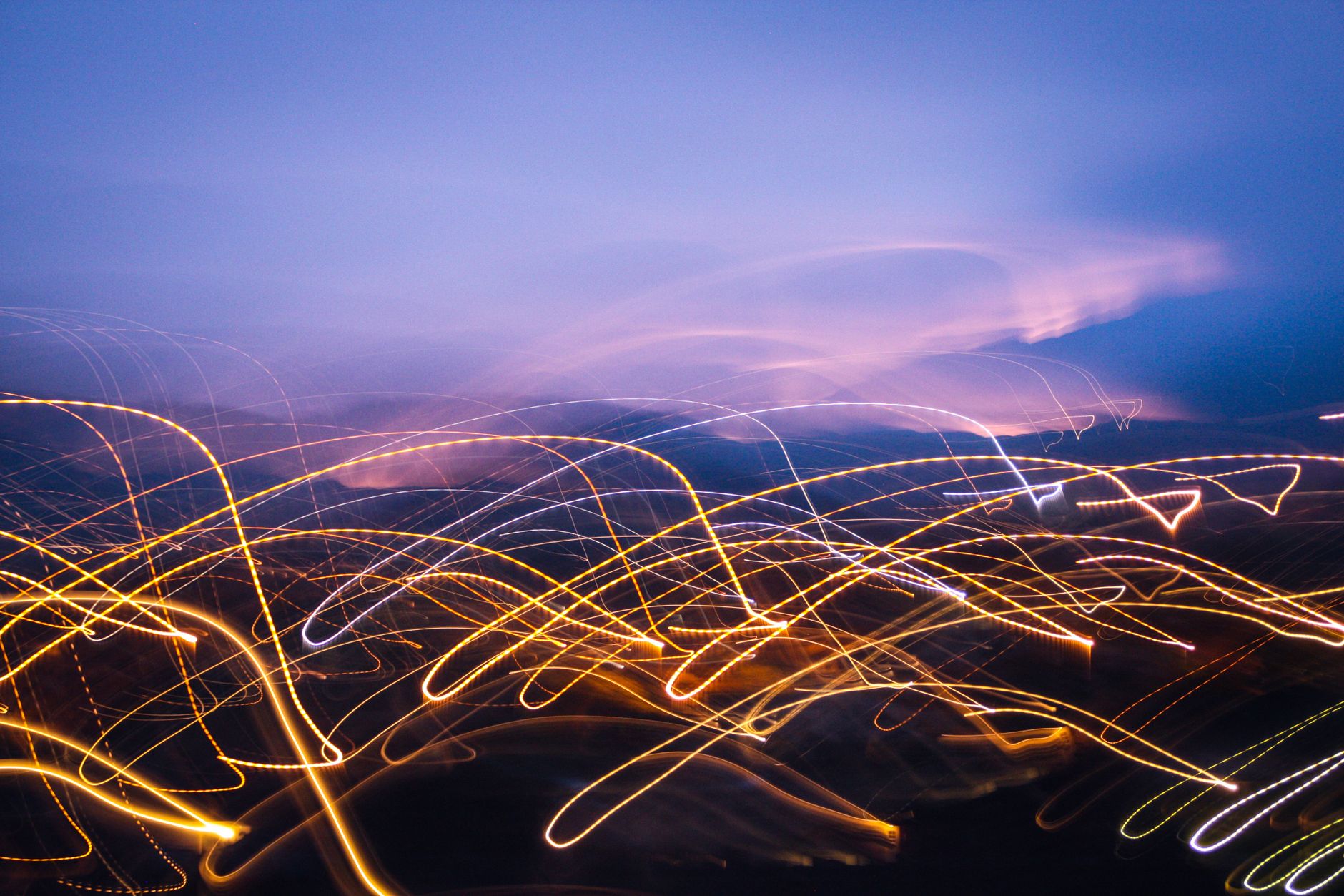 Dynamic abstract light trails in a vibrant night cityscape, evoking a sense of motion and energy.