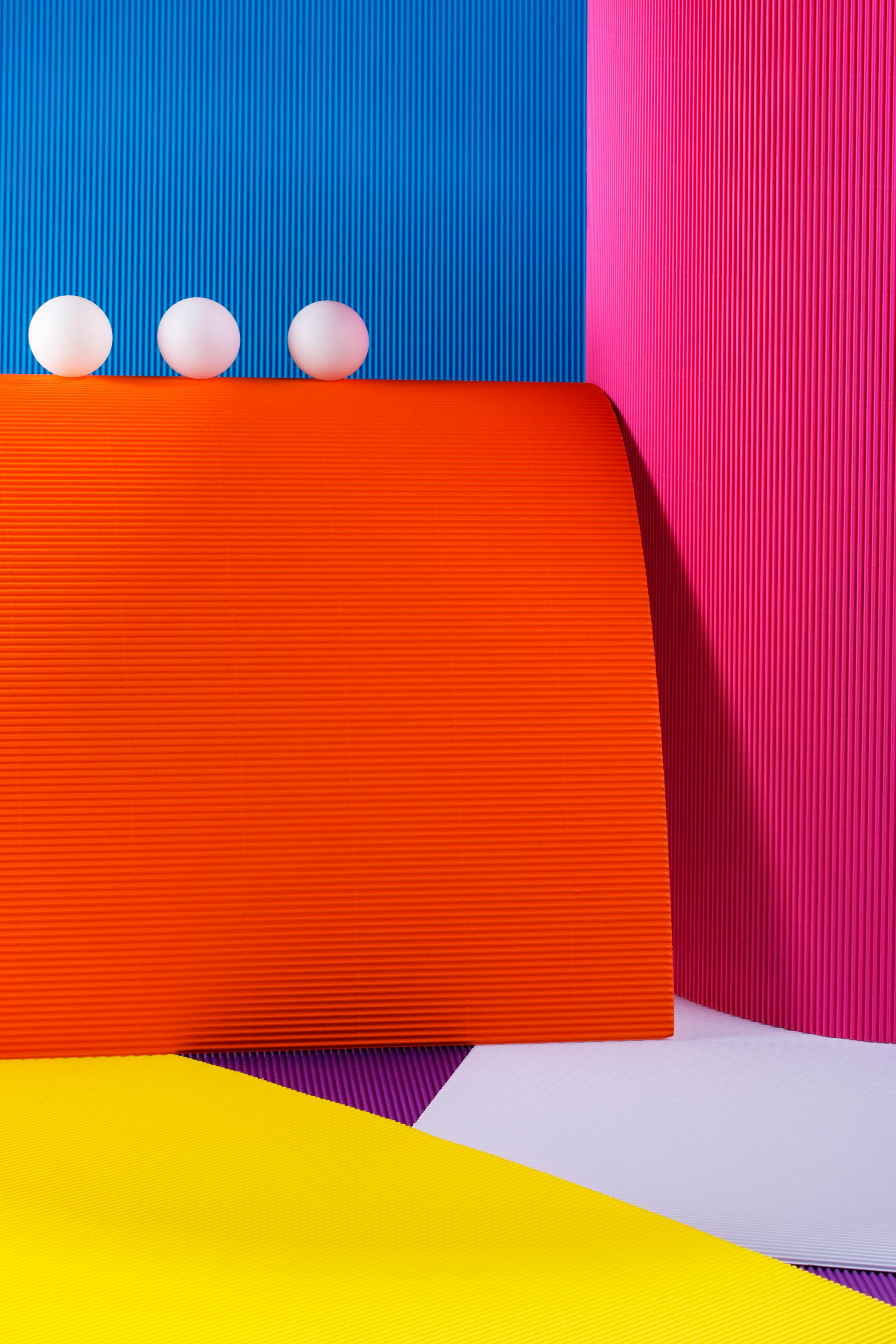 Ücretsiz Minimalist bir tasarımla sergilenen, renkli rulo kağıtlardan ve beyaz toplardan oluşan canlı bir soyut kompozisyon. Stok Fotoğraflar