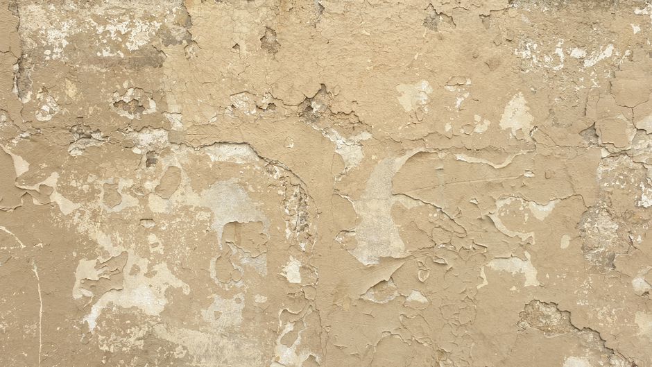 A rustic wall with peeling paint and textured surface, ideal for backgrounds and design projects.