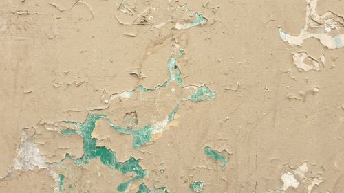 Free Close-up of a wall with peeling paint revealing a weathered texture. Stock Photo