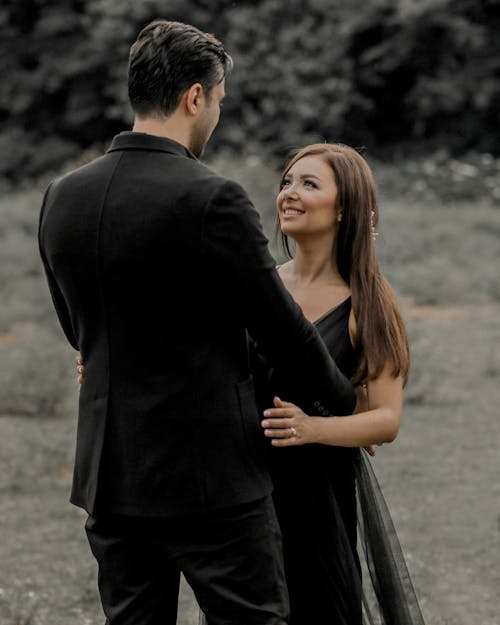 Free Man In Black Long Sleeved Coat And Woman In A Black Dress Stock Photo