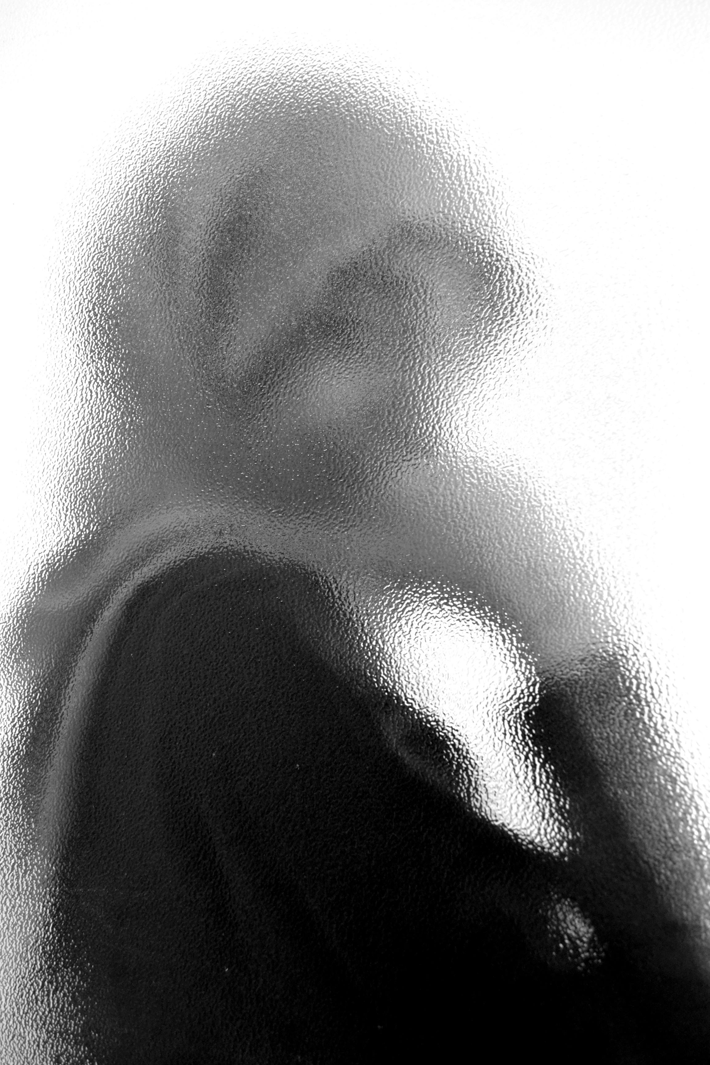 grátis Representação artística de uma figura velada atrás de um vidro fosco, evocando mistério. Foto profissional