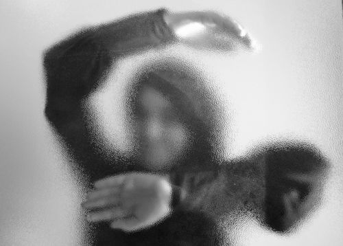 Free A mysterious silhouette of a person behind frosted glass creating an abstract artistic visual. Stock Photo