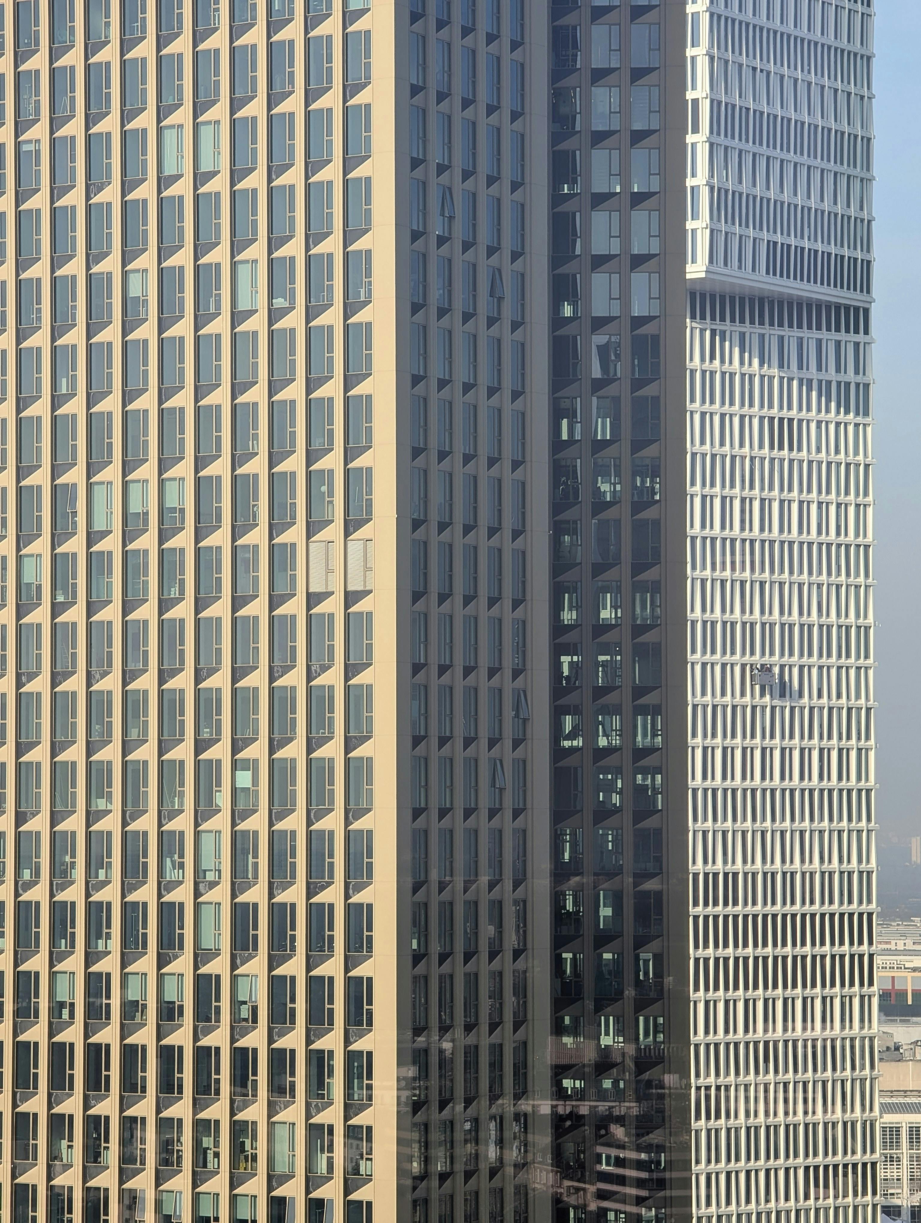 Free Close-up view of contemporary skyscraper design in an urban setting, showcasing geometric patterns and glass facades. Stock Photo