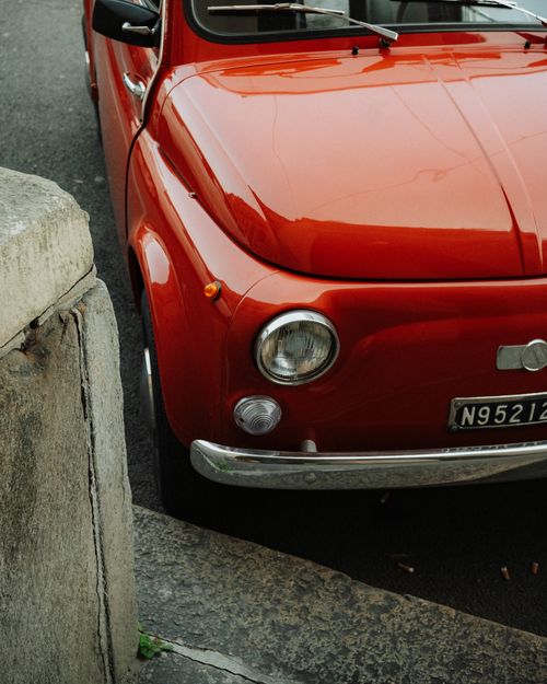 Free Vintage red Fiat 500 parked on a street in Turin, Italy, capturing Italian retro charm. Stock Photo
