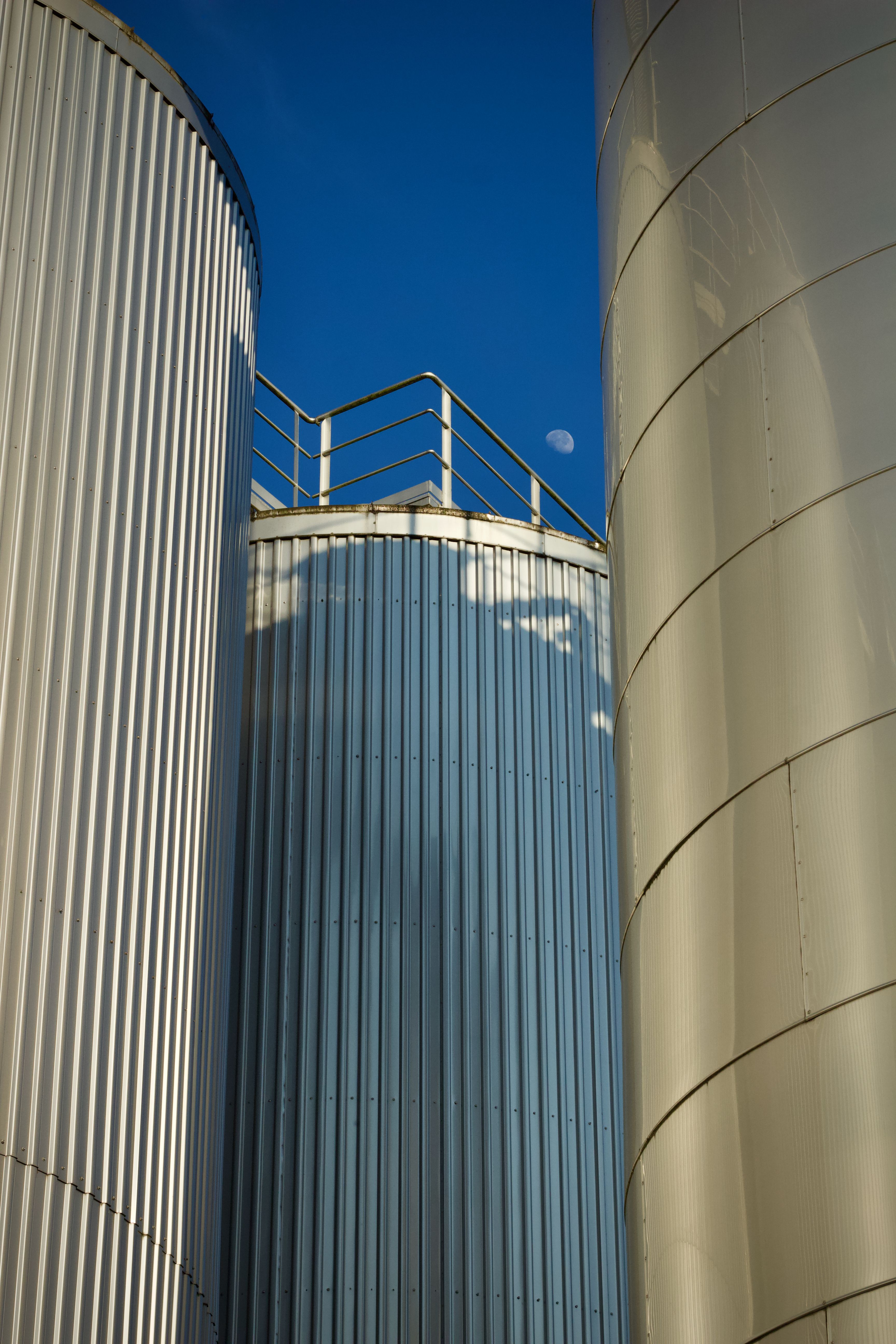 Industrial Silos with Moon in Blue Sky · Free Stock Photo