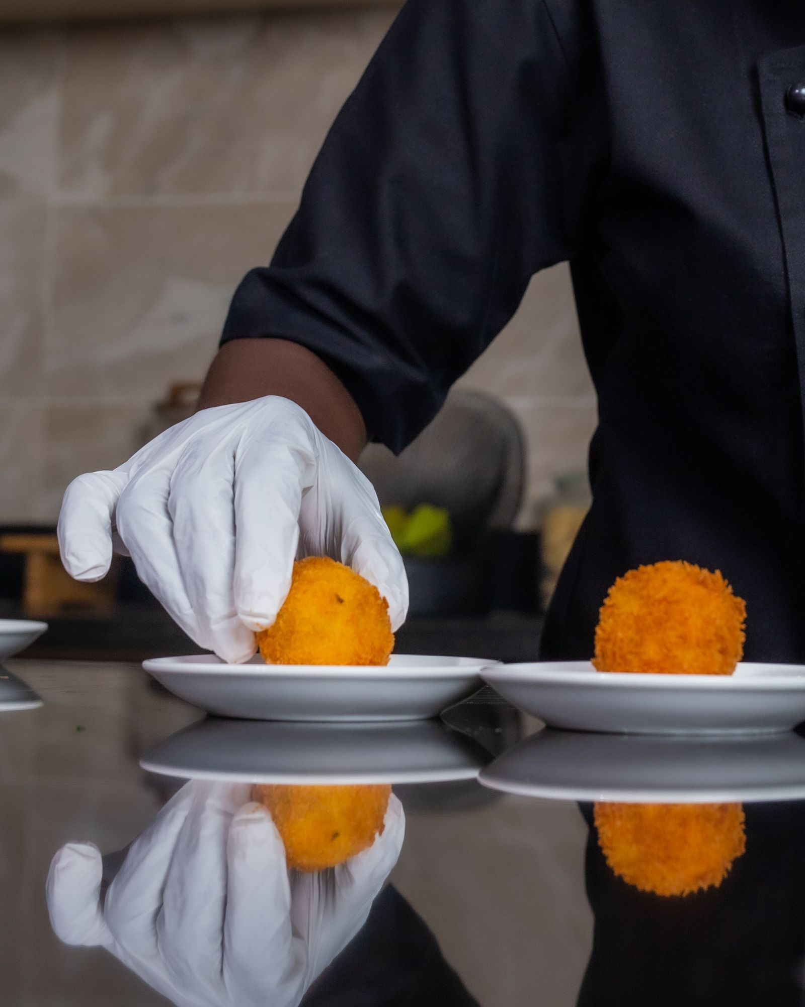 Chef plating a dish under dramatic light