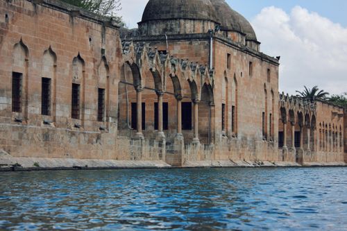 Free Ancient stone architecture alongside tranquil water, capturing history and serenity. Stock Photo