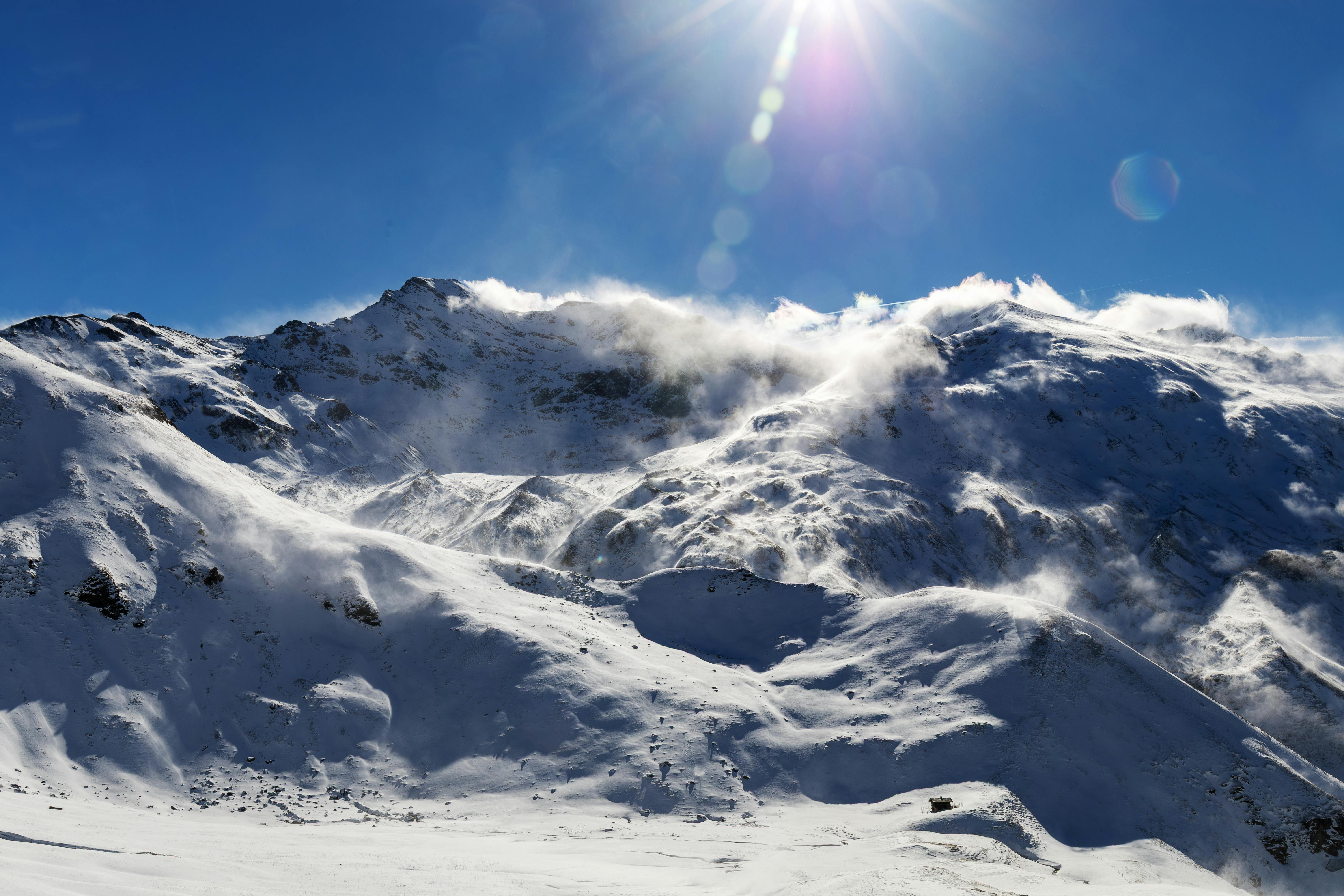 Snow-covered mountains in Salzburg, Austria, basking under a bright, clear sky.