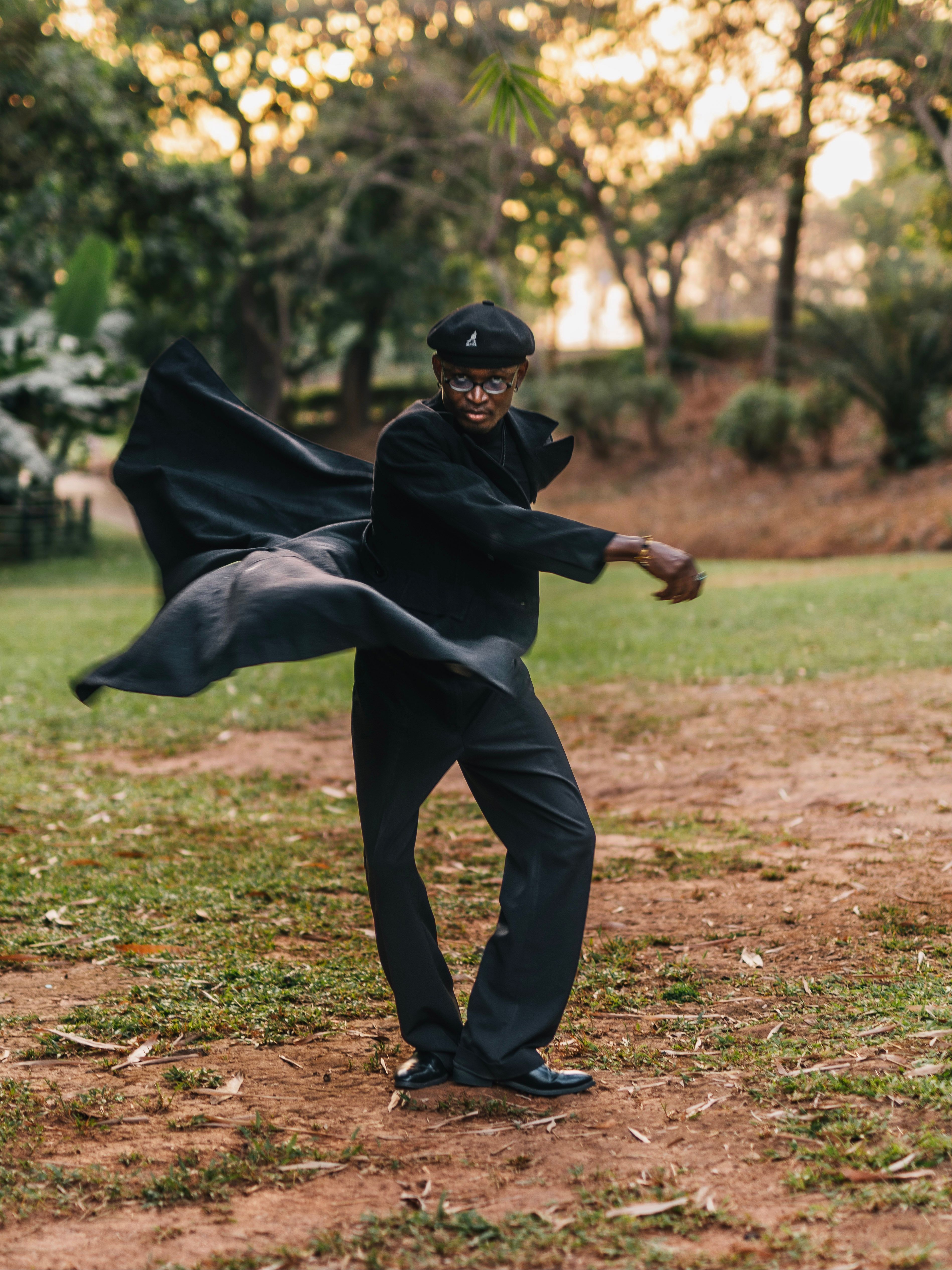 A man twirls in a park in Abuja, Nigeria, exuding energy and grace at sunset.