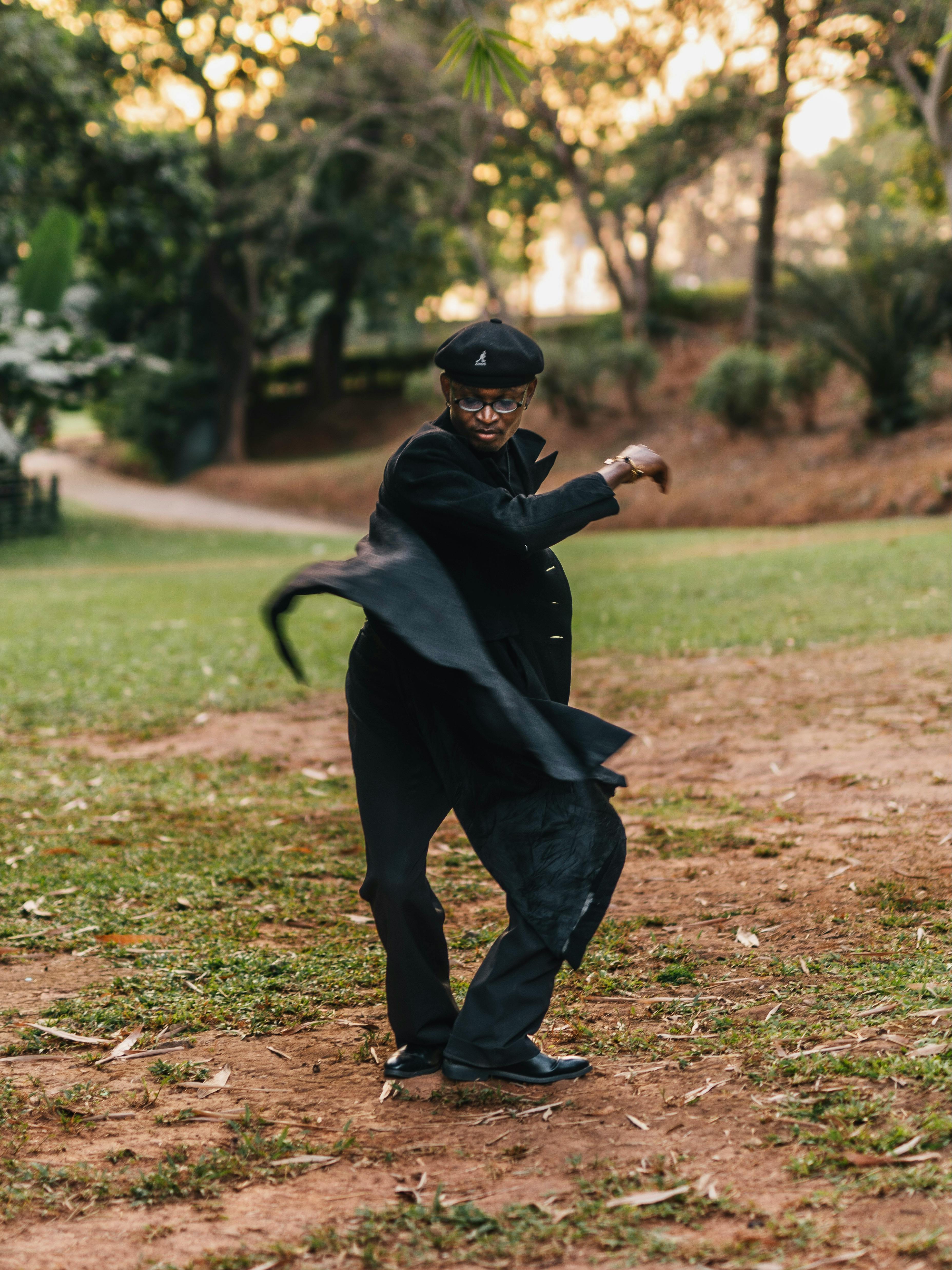 Kostnadsfria En moderiktig man i rörelse, som dansar glatt i en park i Abuja under dagen. Stock foto