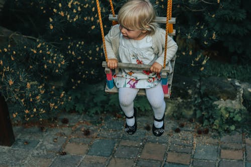 Free Girl in White Jacket Riding on Swing Stock Photo