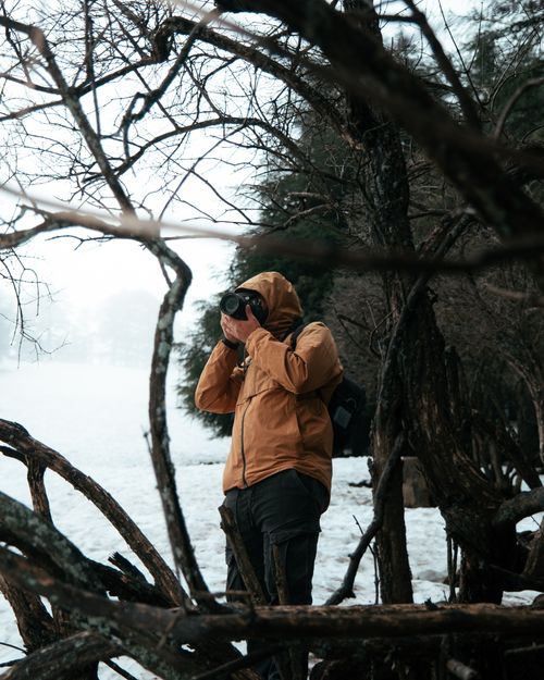 Free A solitary photographer in a snowy winter landscape captures nature's serene beauty through the lens. Stock Photo