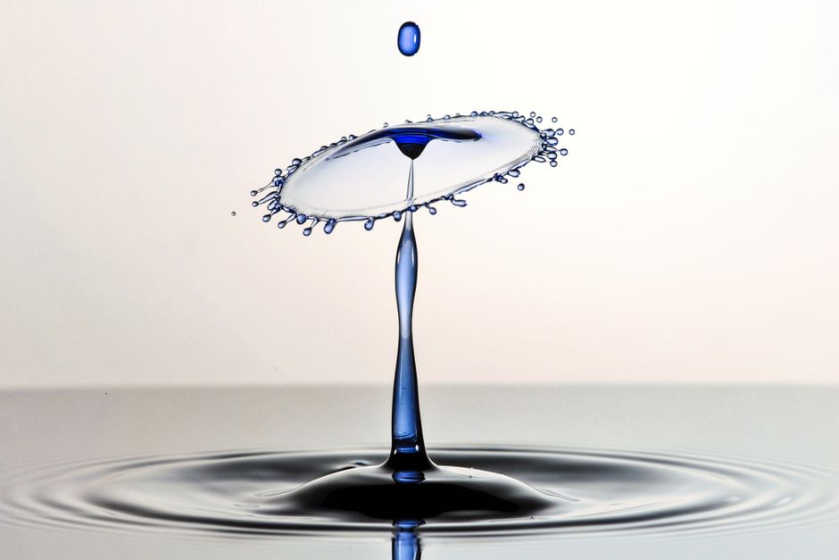 Macro capture showcasing the intricate collision of water droplets with vivid detail and artistic symmetry.