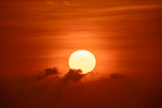 A stunning sunset over Bali with a vibrant sun and fiery clouds in the sky.