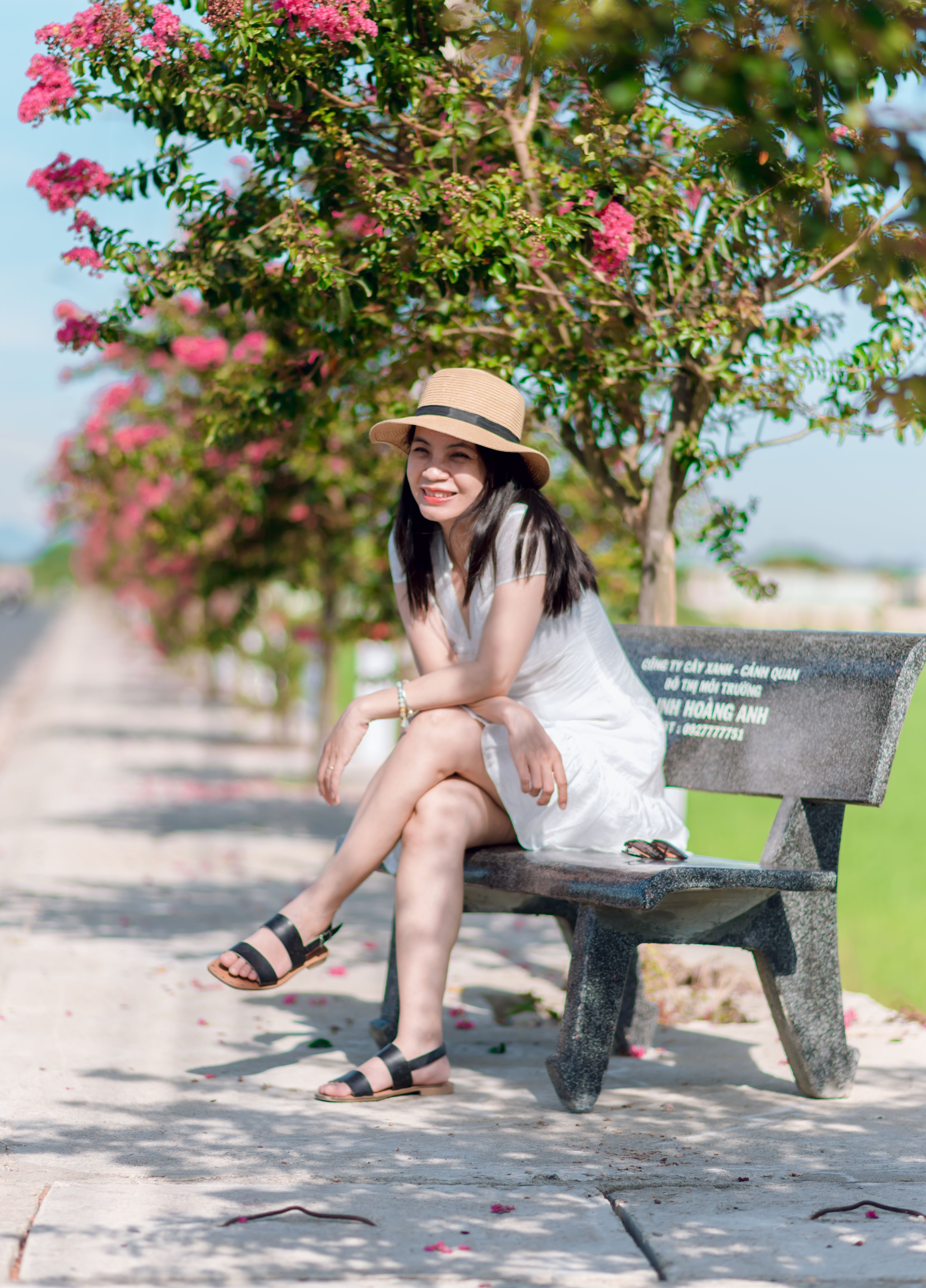 Smiling Woman Relaxing on a Park Bench in Summer · Free Stock Photo