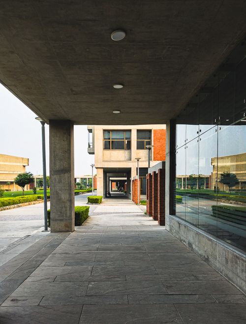 Free Symmetrical corridor with modern design and reflective surfaces on a sunny day. Stock Photo