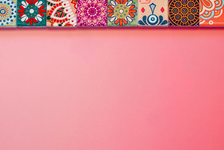 Vibrantly colored tiles with intricate patterns on a pink pastel background, perfect for creative design projects.