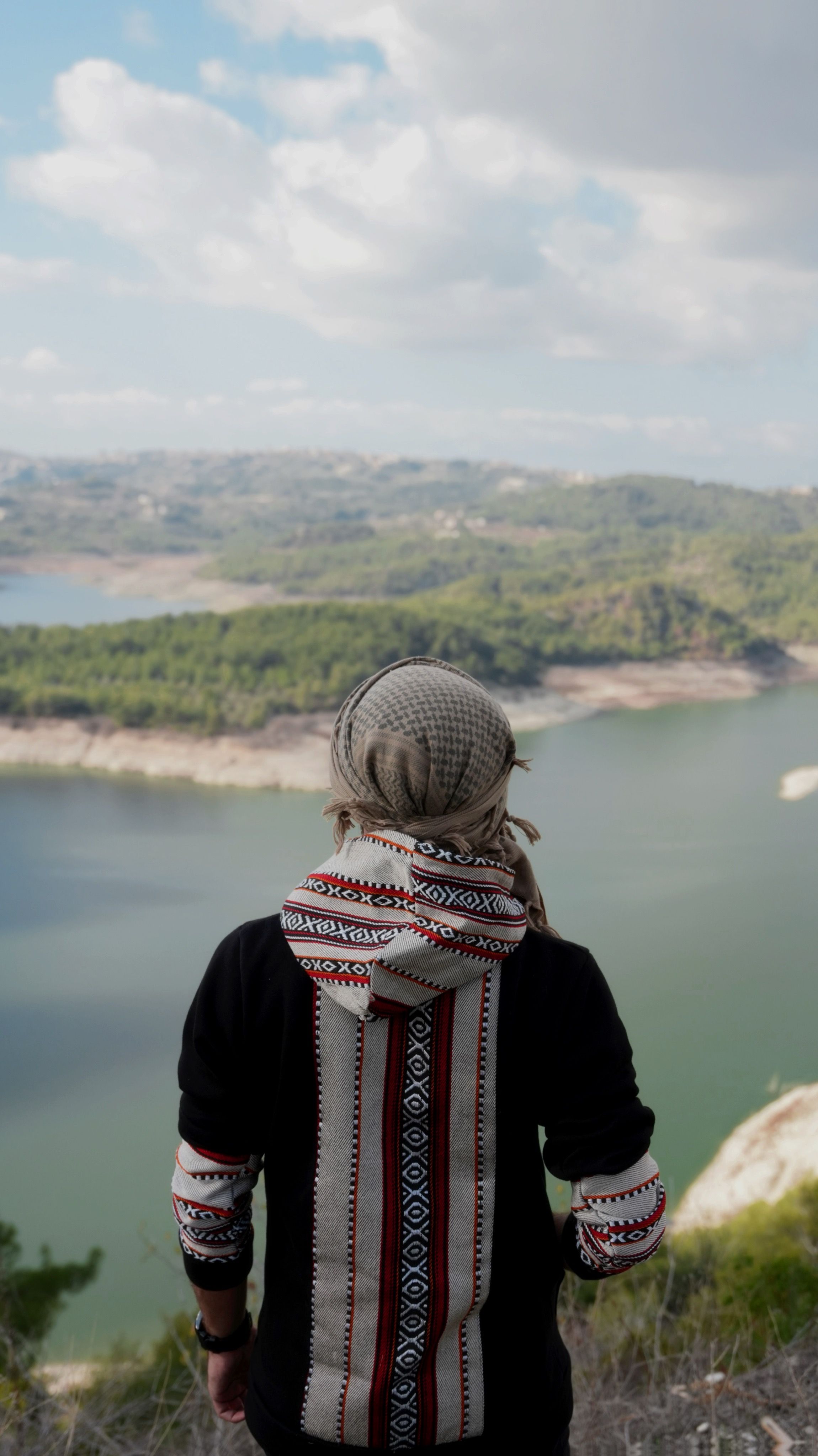 A person gazes upon the scenic Mashqita Lake in Syria. A serene travel moment.