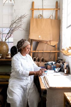 Artisan creating handmade items in a cozy workshop setting with natural light.