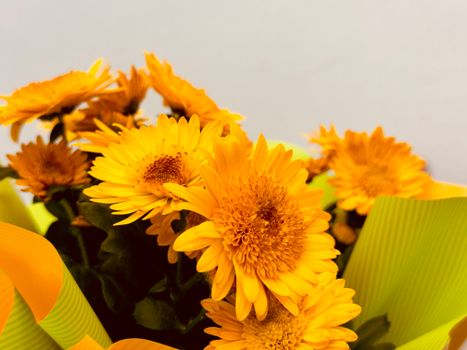 Close-up view of vibrant yellow chrysanthemums arranged in a bouquet, perfect for brightening any setting.