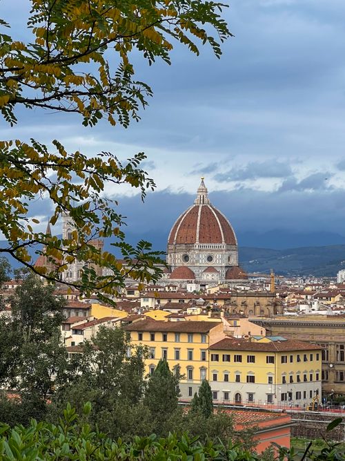 Free Breathtaking view of Florence Cathedral's dome with autumn foliage, showcasing the Duomo's architecture. Stock Photo