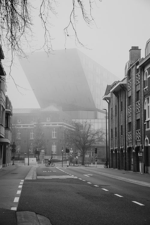 Free A misty city street in Hasselt, Belgium, showcasing modern and classic architecture. Stock Photo