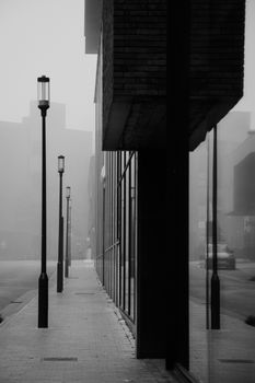 Misty morning view of a quiet urban street in Hasselt with architectural lines.