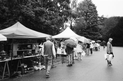 Free Vintage black and white photo capturing a bustling flea market in Nancy, France with people and stalls. Stock Photo