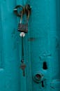 Rusty Padlock and Key on Turquoise Door Close-Up