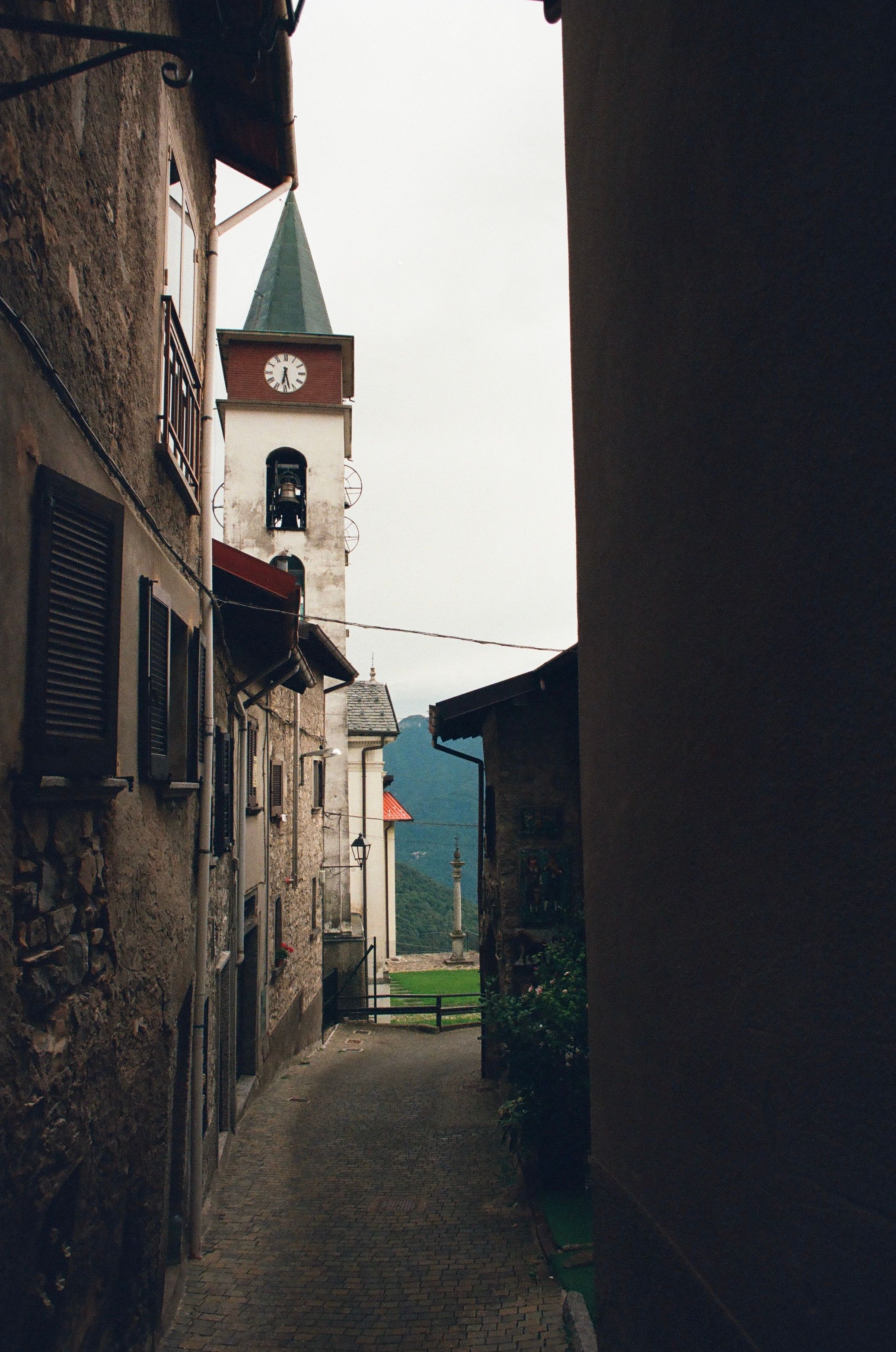 Gratis Pittoresco vicolo lombardo con una rustica torre dell'orologio in una giornata nuvolosa. Foto a disposizione