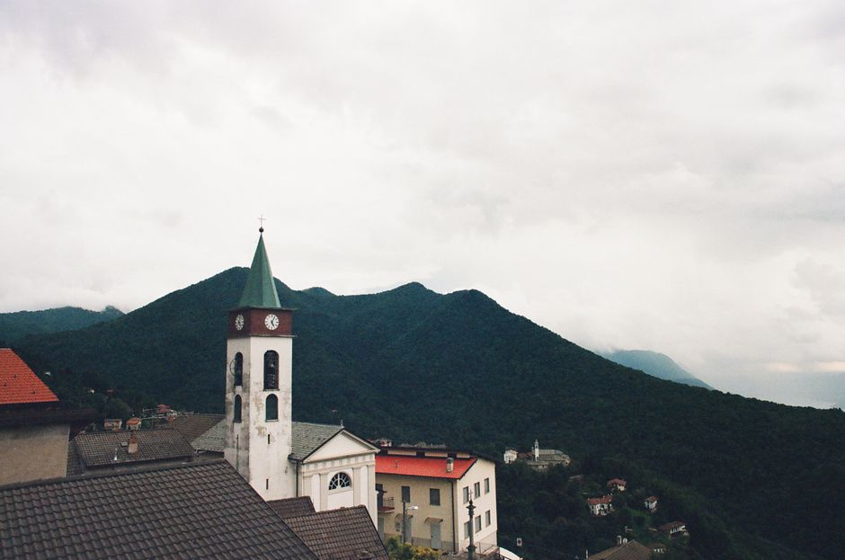 Charming Italian village with a church tower against mountain backdrop in Lombardia, Italy.