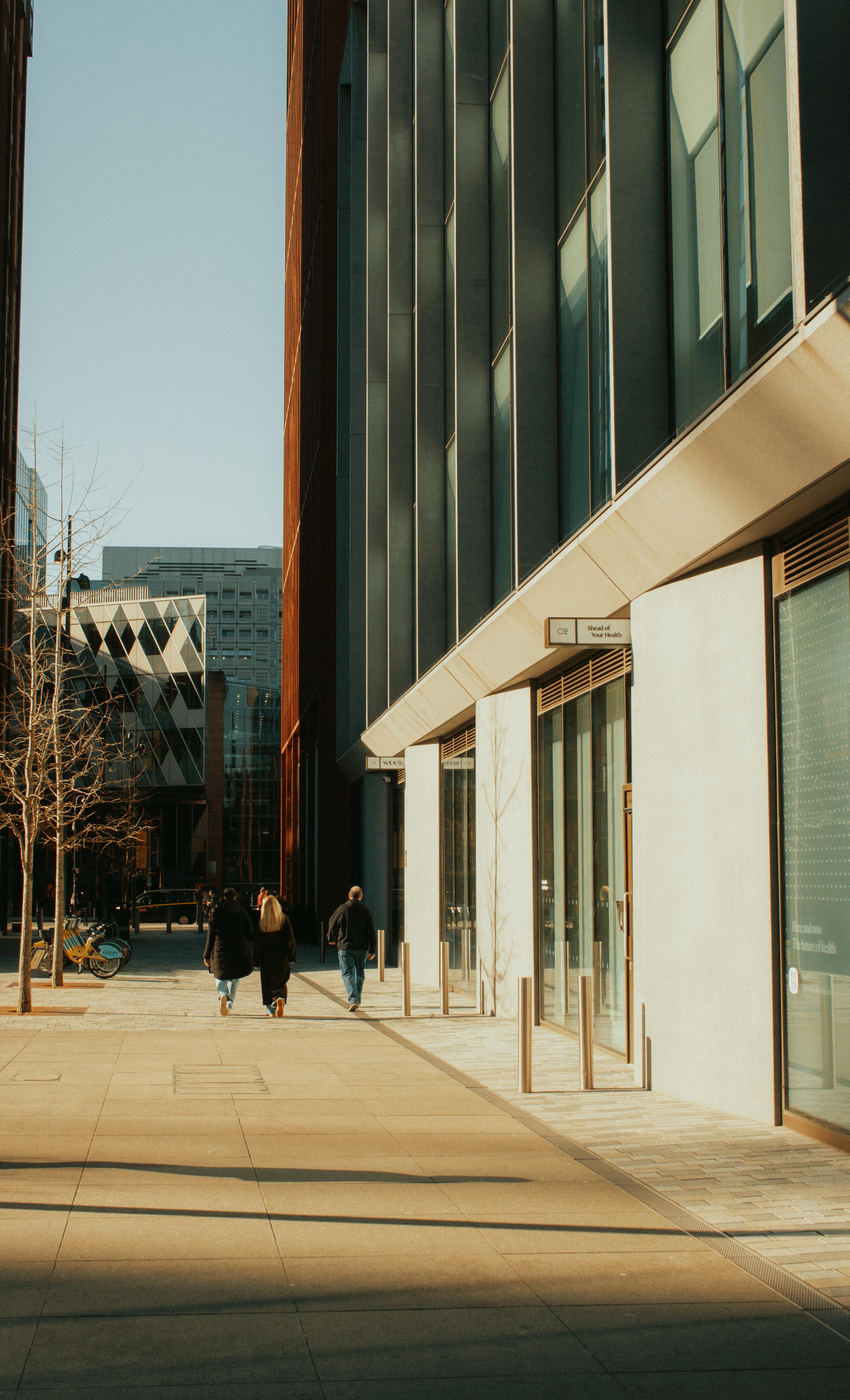 Gratis Strada urbana con pedoni che camminano lungo edifici moderni a Manchester, Inghilterra. Foto a disposizione