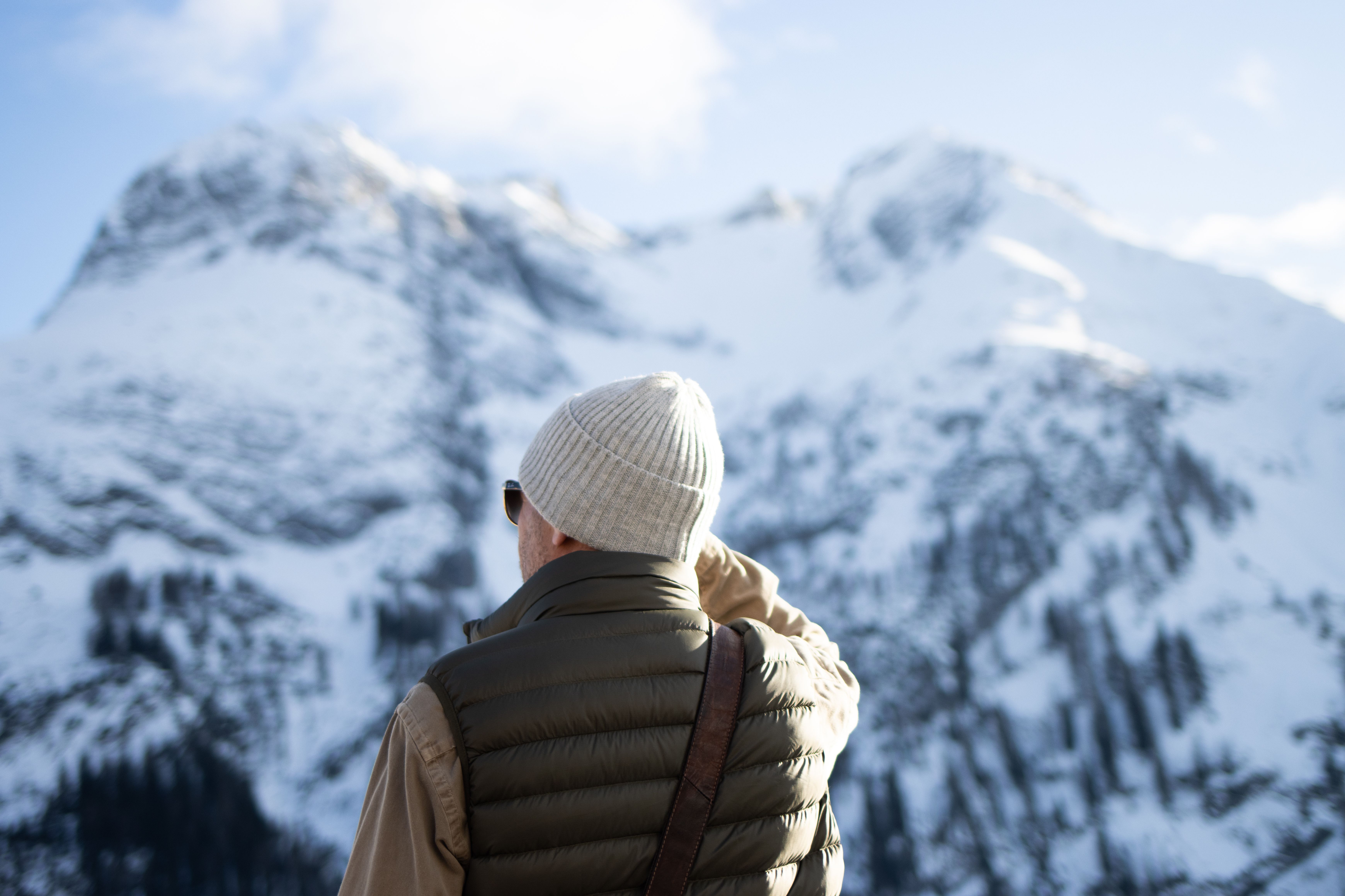 Man in Winter Gear Admiring Snowy Mountains