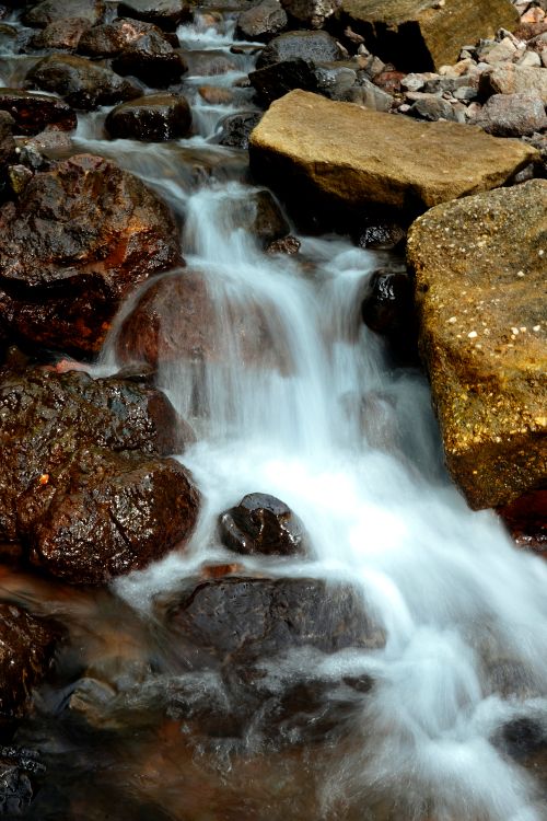 Free A peaceful waterfall cascades over rugged rocks, creating a serene natural scene. Stock Photo