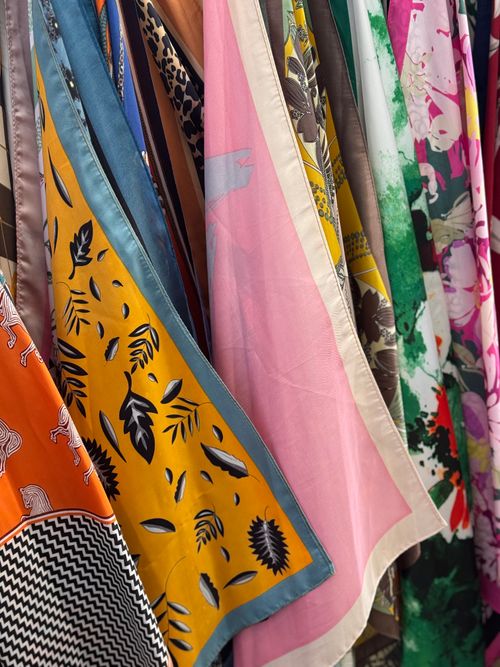 Free Vibrant collection of diverse patterned fabrics in various colors hanging in layers. Stock Photo