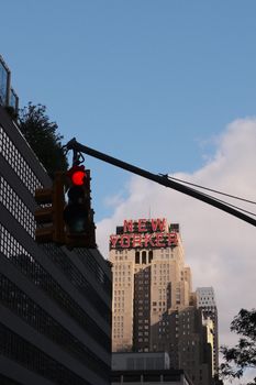 View of the New Yorker Hotel with a traffic light foreground, capturing NYC's urban essence.