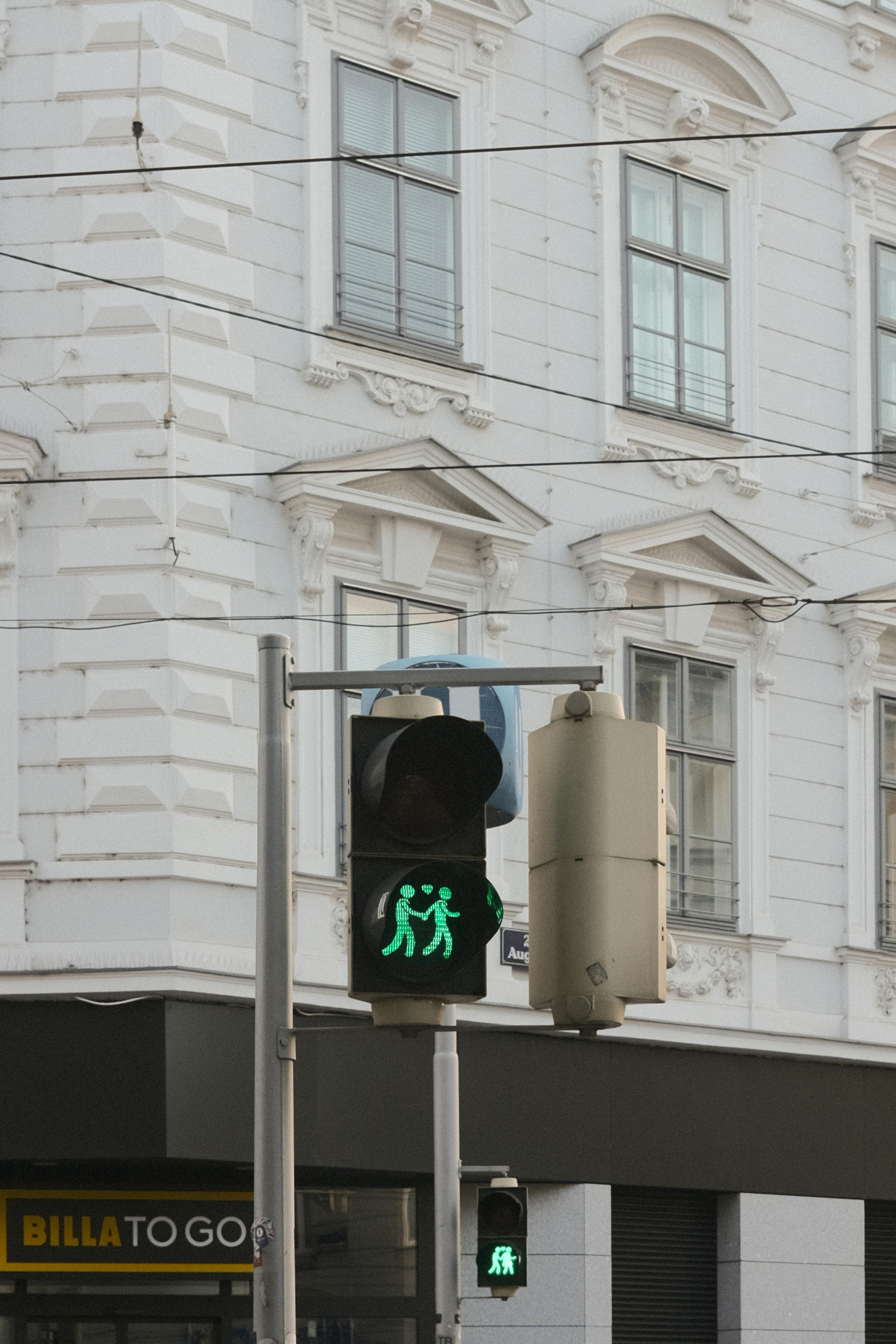 Gratis Et grønt fotgjengerlys med et unikt symbol nær en historisk bygning i Wien, Østerrike. Arkivbilde