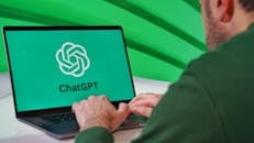 Man Using ChatGPT on Laptop with Green Background