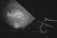 Monochrome image of Ramadan welcome sign with lanterns and crescent decorations.