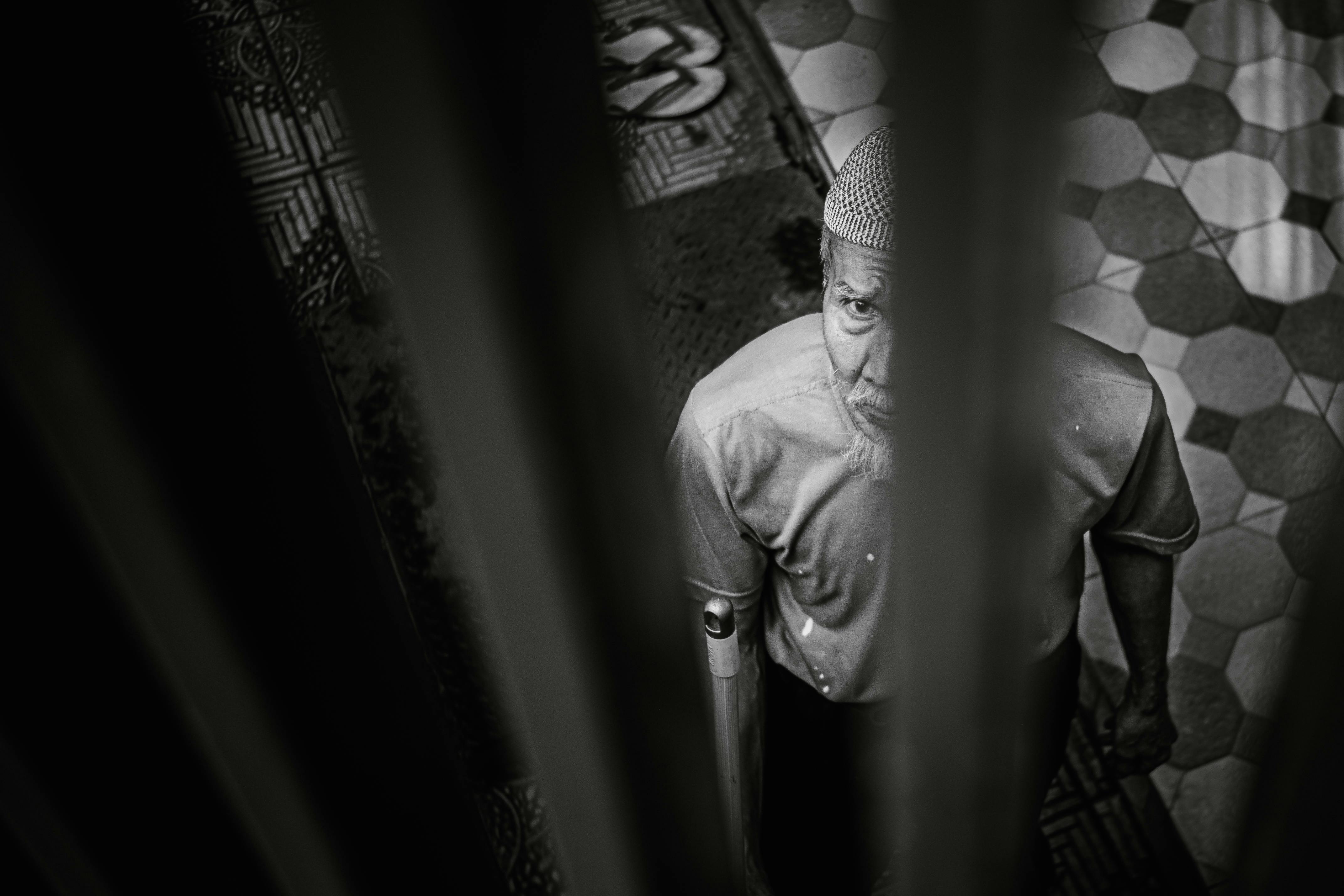 Kostenlos Stimmungsvolles Schwarz-Weiß-Porträt eines älteren Mannes mit traditioneller Mütze, der nach oben blickt. Stock-Foto